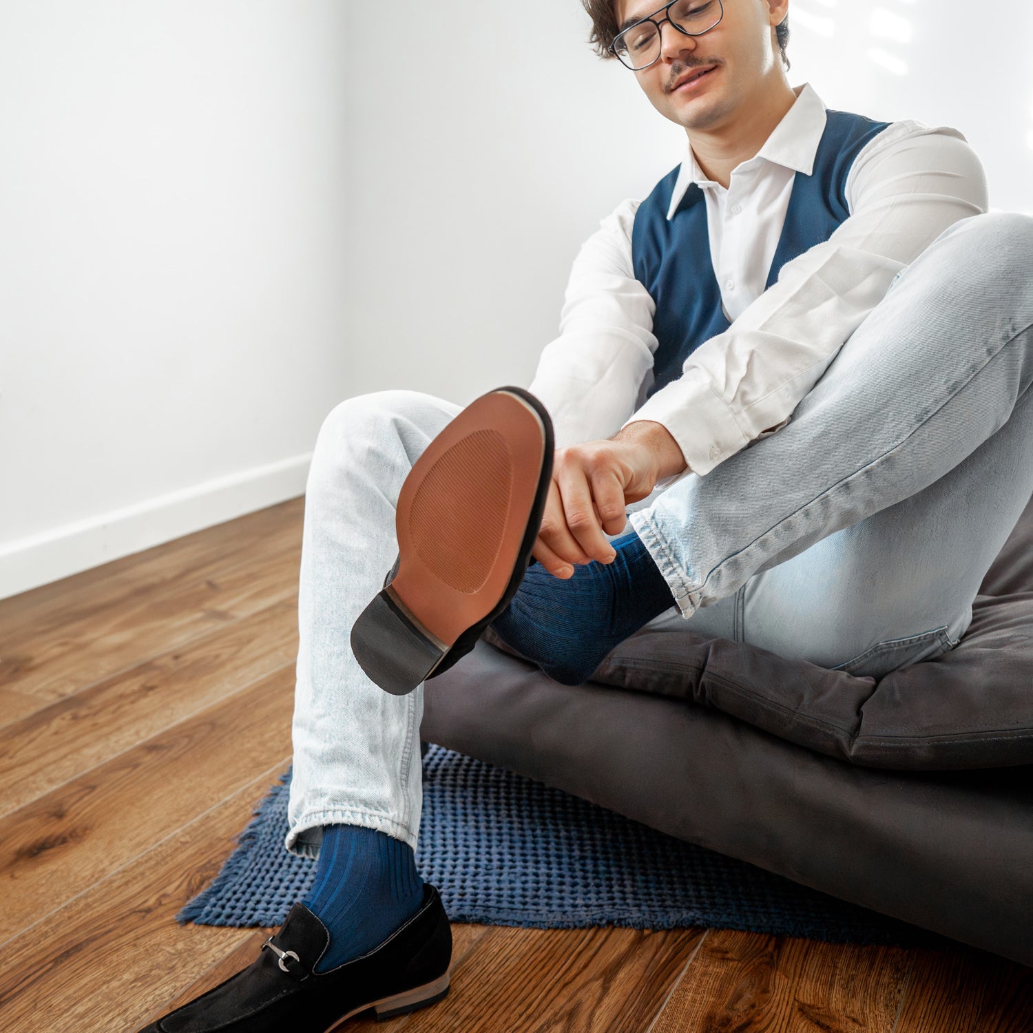 Mann trägt blaue Businesssocken von BLACKSOCKS zu Jeans und schwarzen Loafers.